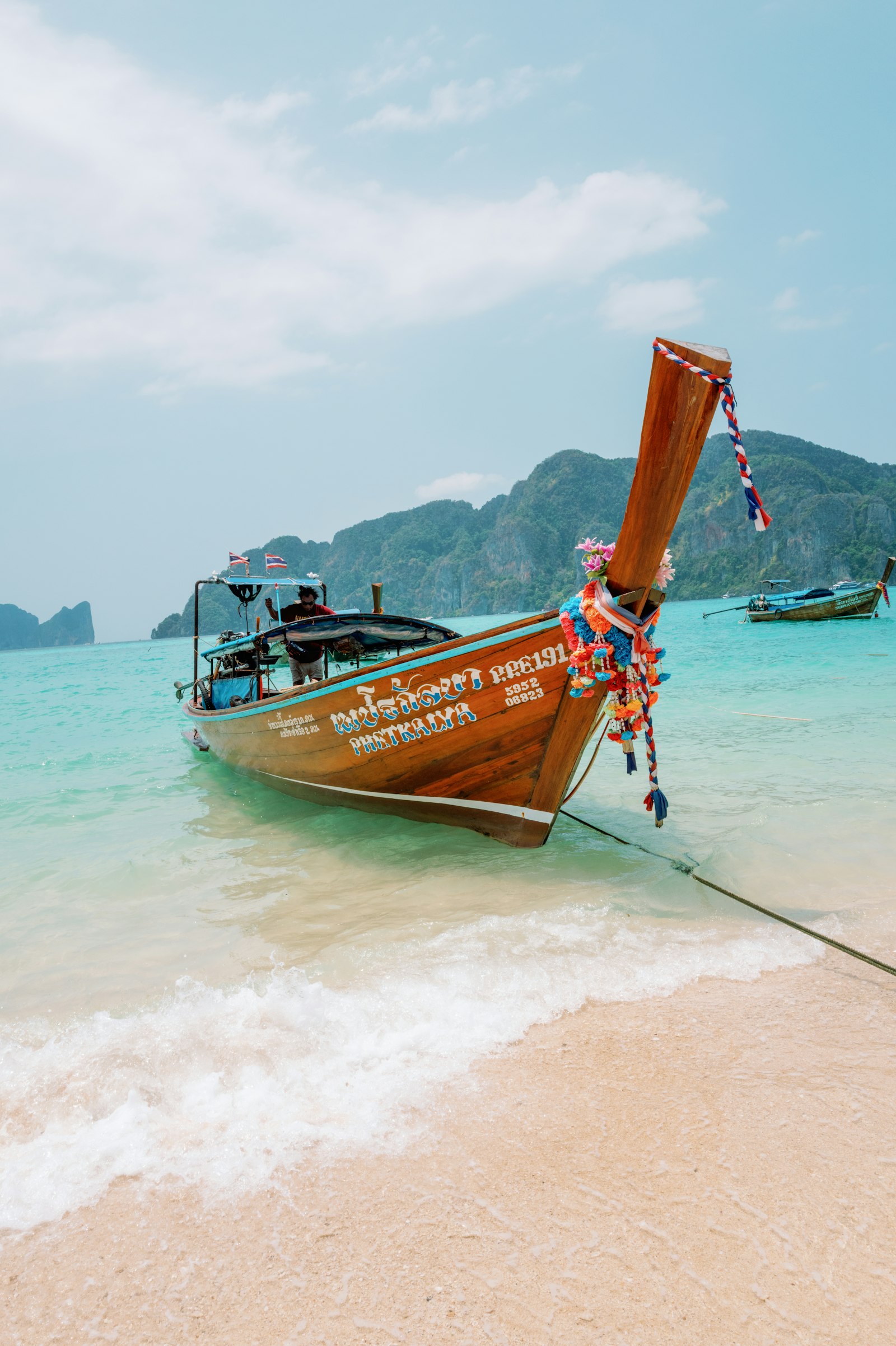 Traditional long-tail boat on a tropical Thailand beach.